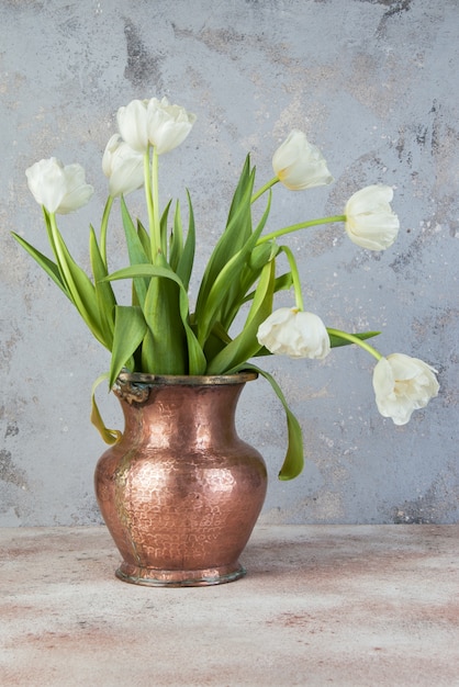 Tulipas brancas em vaso de cobre velho