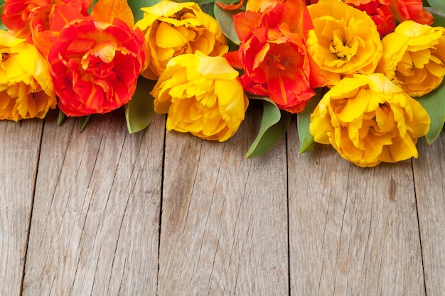 Tulipas coloridas na mesa de madeira