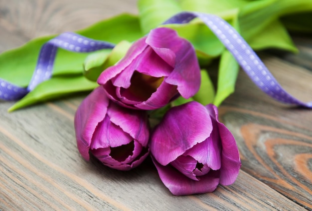 Tulipas com fita em fundo de madeira