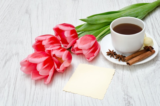 Tulipas cor de rosa, caneca de café e canela.