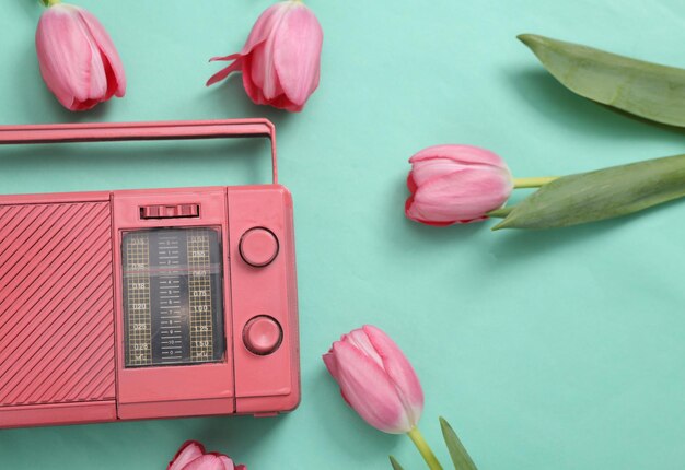 Foto tulipas cor de rosa com rádio fm no fundo azul conceito de amor de música romântica flat lay