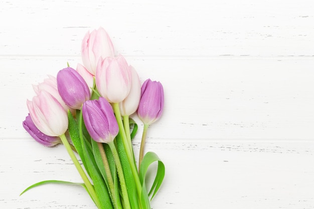 Tulipas cor de rosa sobre fundo de madeira