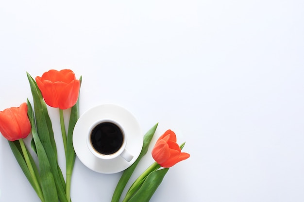 Tulipas vermelhas e xícara de café no fundo branco Dia Internacional da Mulher 8 de março Bom dia café