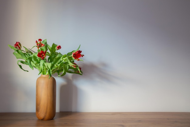 tulipas vermelhas em vasos modernos em parede cinza de fundo