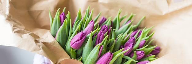 Foto tulipas violetas em papel artesanalmuitas tulipas em papel de embrulho marrom tom silenciado decoração floral de férias de primavera cartão de felicitações para 8 de março, dia das mães, dia dos namorados, dia dos pais