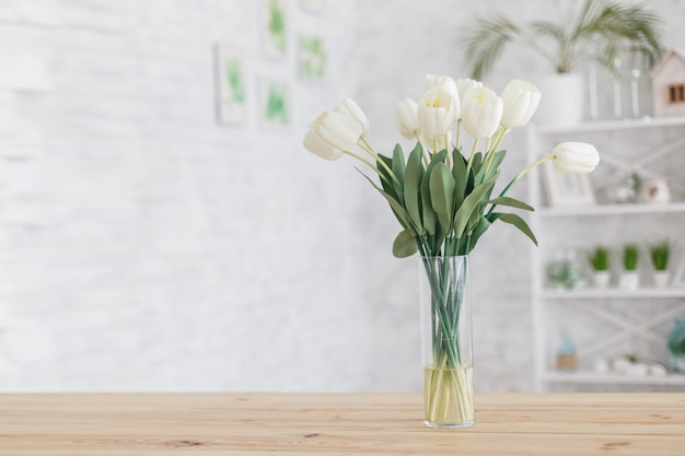 Tulpen in einer Vase auf einem Holztisch. Skandinavisches Interieur.