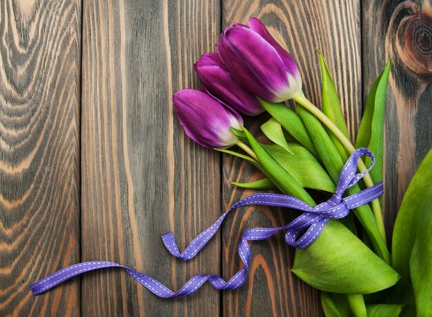 Tulpen mit Band auf einem hölzernen Hintergrund