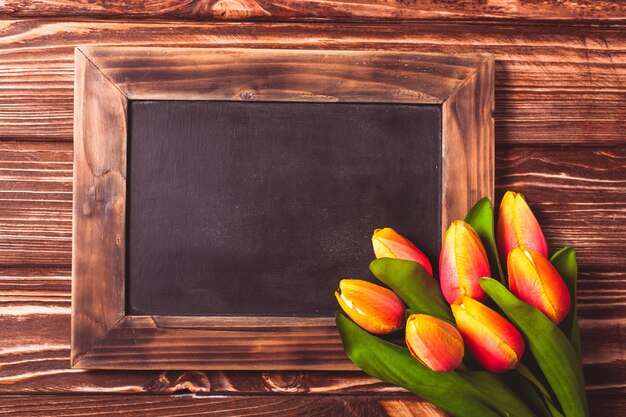 Tulpen mit Tafel auf Holzuntergrund - Frühlingsgrüße