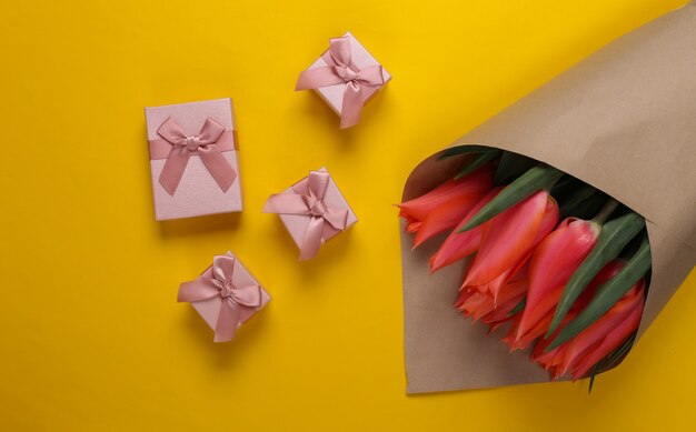 Tulpenstrauß mit Geschenkboxen auf Gelb