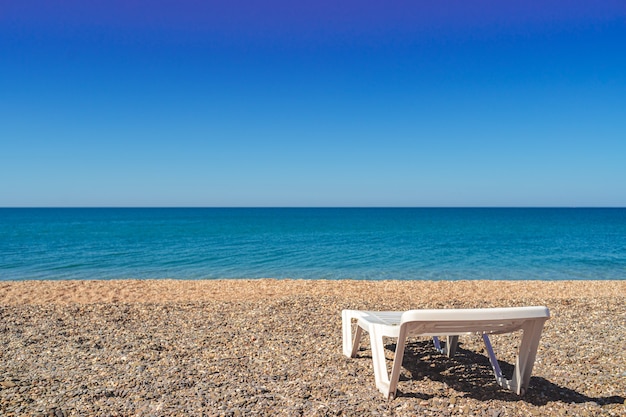 Foto tumbona blanca vacía en la playa, nadie