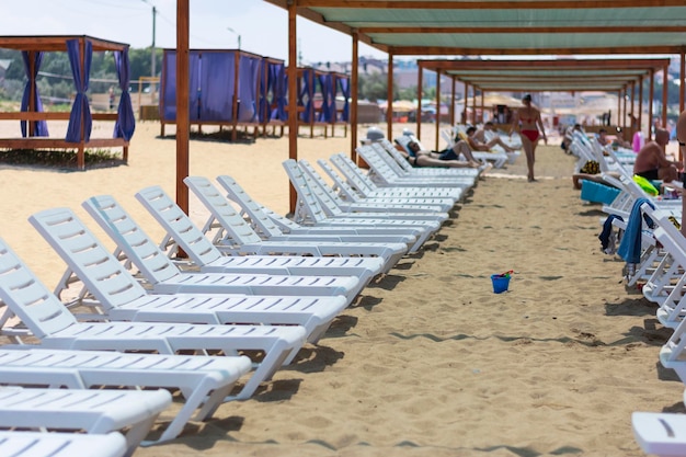 Tumbonas blancas en la playa en verano de vacaciones