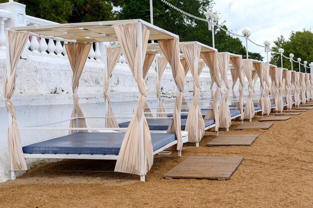 Foto las tumbonas blancas de verano en una playa vacía acampando