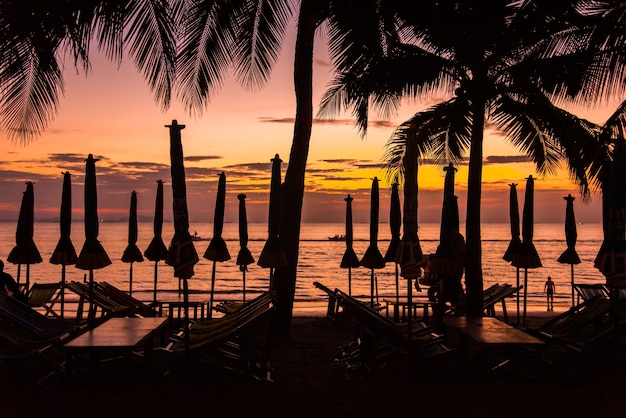 Foto tumbonas de fila en la playa al atardecer.