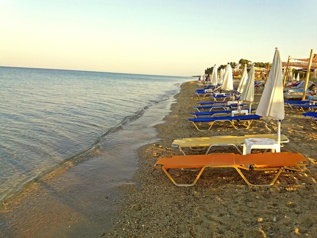 Tumbonas en la orilla del mar Mediterráneo griego Playa griega al amanecer.