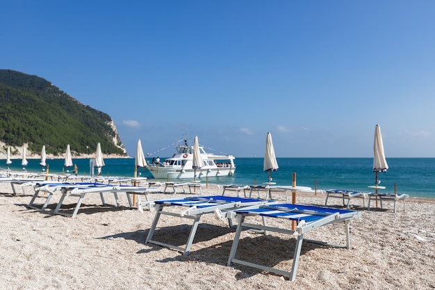 Tumbonas de playa vacías esperando a los vacacionistas en una hermosa playa