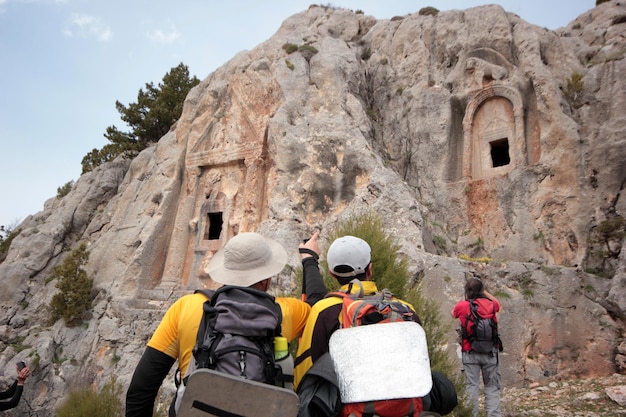 Túmulos de reis esculpidos na rocha do período romano turistas tirando fotos