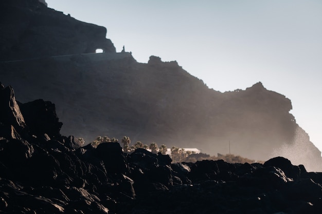 Túnel através da montanha de Tenerife, rochas ao pôr do sol perto do oceano Atlântico da ilha de Tenerife. Ilhas Canárias. Espanha