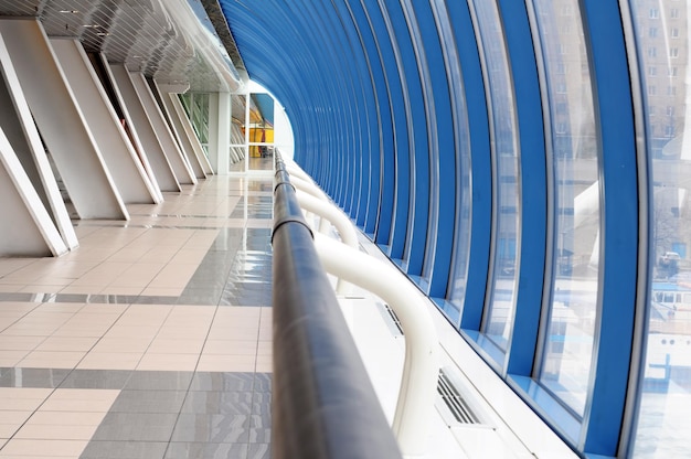 Un túnel azul y blanco con una barandilla azul y una pared azul.