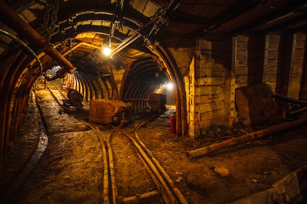 Túnel minero subterráneo con rieles.