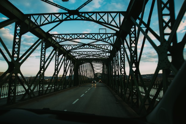 Túnel de un puente de metal para automóviles sobre un río.