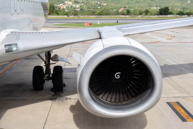 Turbina do avião do motor 737-400 no fundo tropical do aeroporto.