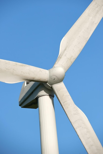 Una turbina eólica y palas de rotor aisladas contra un cielo azul en una granja ecológica sostenible Vista de ángulo bajo de la cosecha de una fuente de energía biodegradable para generar electricidad a partir de climas ventosos