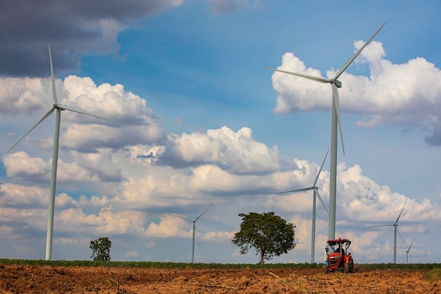 Turbina de viento en la hierba marrón del tractor sobre la montaña el cielo azul