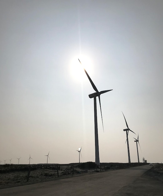 Turbinas eólicas en el campo contra el cielo durante la puesta del sol