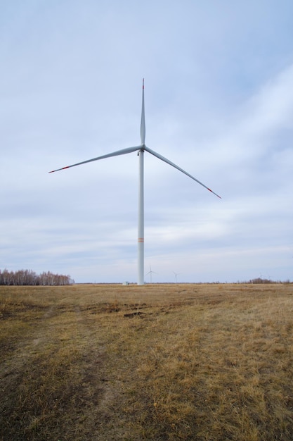 Turbinas eólicas em um campo com grama amarela e contra um céu nubladoenergia renovável ecologicamente correta