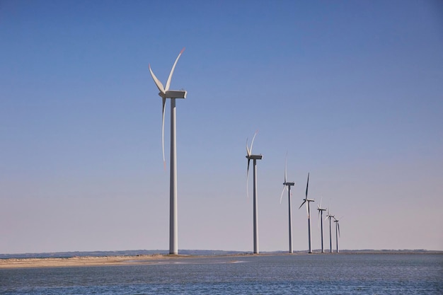 Turbinas eólicas no Mar do Norte, na Dinamarca, ao pôr do sol