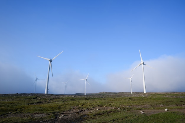 Turbinas eólicas no nevoeiro. fundo azul com espaço de cópia para o texto. energia renovável