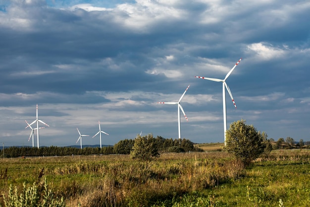 Turbinas de viento en colinas verdes Grupo de molinos de viento para la producción de energía eléctrica en el verde