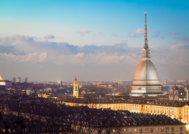 Turín, región de Piamonte, Italia. Panorama desde el Monte dei Cappuccini (colina de Cappuccini) al atardecer con las montañas de los Alpes y el monumento Mole Antonelliana.