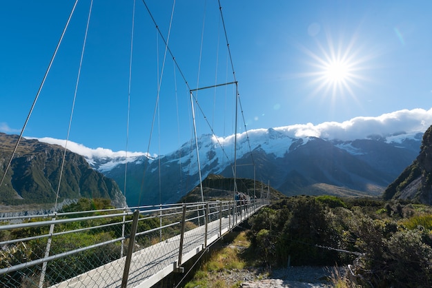 Turismo andando na ponte suspensa sobre o rio na nova zelândia