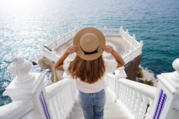 Turismo em Alicante, Espanha. Vista traseira da menina viajante desce escadas do Balcon del Mediterraneo em Benidorm, Alicante, Espanha. Jovem turista feminina visitando o sul da Europa.