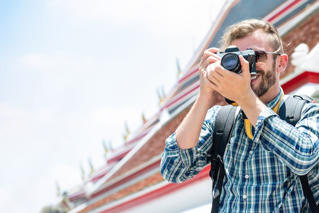 Turismo masculino tirando foto enquanto viaja de férias em bangkok tailândia