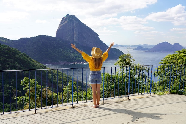 Foto turismo no rio de janeiro bela viajante grata menina levantando os braços olhando teleféricos sobe de urca hill para sugarloaf mountain patrimônio mundial da unesco rio de janeiro brasil