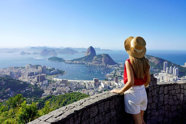 Turismo no Rio de Janeiro Vista de trás de uma menina viajante desfrutando da vista da famosa Baía de Guanabara com a Montanha do Pão de Açúcar no Rio de janeiro Patrimônio Mundial da UNESCO Brasil