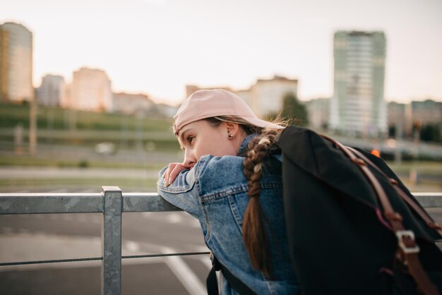 Turista admira la visión general de los lugares de interés de la ciudad Mujer con mochila disfruta de una hermosa vista de la ciudad viajero simulacro en la parte superior de la ciudad