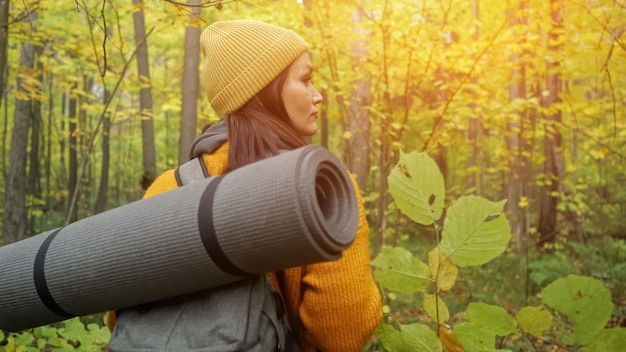 Una turista adulta con mochila gris explora un espeso bosque