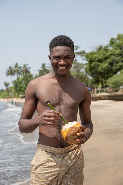 Turista africano de férias numa praia natural aberta ao Oceano Atlântico