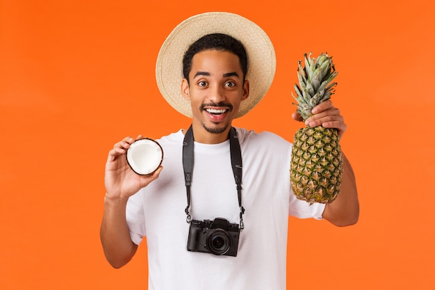 turista afro-americano segurando frutas tropicais