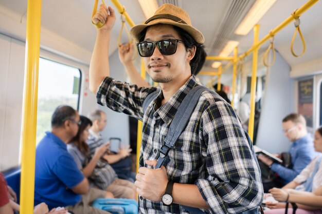 Turista asiático do bloco do saco do homem em um trem.