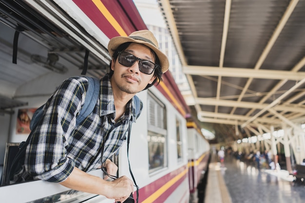 Turista asiático do bloco do saco do homem na estação de trem em Tailândia.