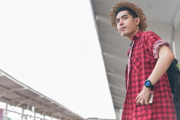 Turista asiático esperar tren en la estación de tren tailandia hipster hombre ir a viajar