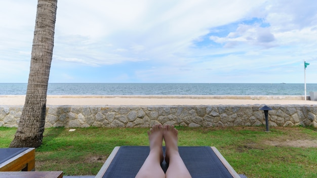 Turista asiático relajante en la silla viendo la belleza de la playa de Hua Hin