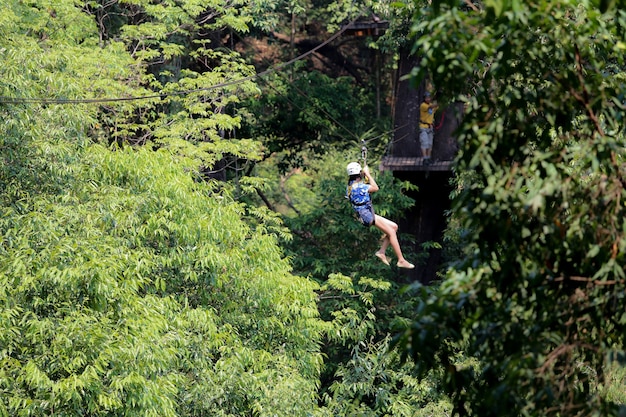 El turista de aventura colgando honda sobre el bosque