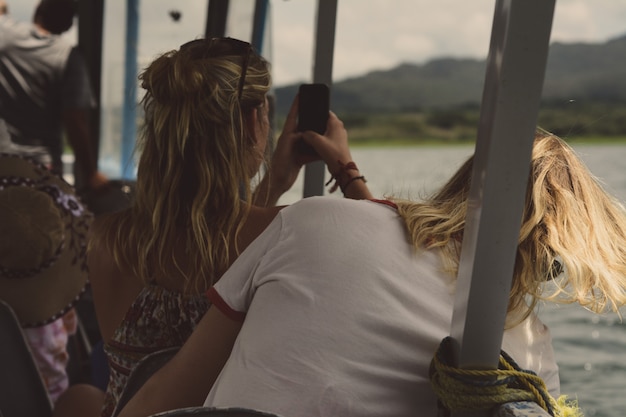 Foto turista en un bote tomando fotos con su teléfono