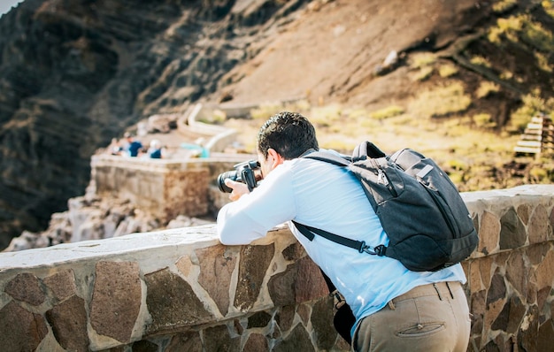 Un turista con una cámara de fotos tomando fotos en un mirador Hombre aventurero con su cámara tomando fotos en un mirador Primer plano de un turista tomando fotos en un mirador volcánico