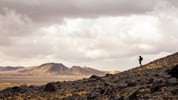 Un turista camina por el desierto blanco y negro de Egipto